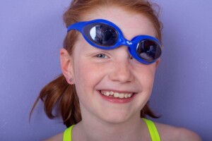 Lustiges Portrait eines jungen Mädchens mit Schwimmbrille