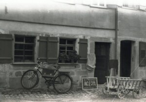 Ein Fahrrad steht vor einem Wohnhaus im Hohenloher Freilandmuseum - historische Fotografie mit antiker Kameratechnik