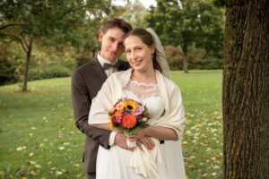 Nach der Hochzeit strahlt das frisch vermählte Paar in die Kamera - Hochzeitsfotos München