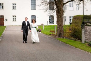Hand in Hand spaziert das frisch gebackene Ehepaar durch den Garten des Kloster Fürstenfeld